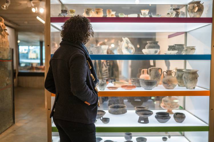Person looking at pottery exhibit in a museum