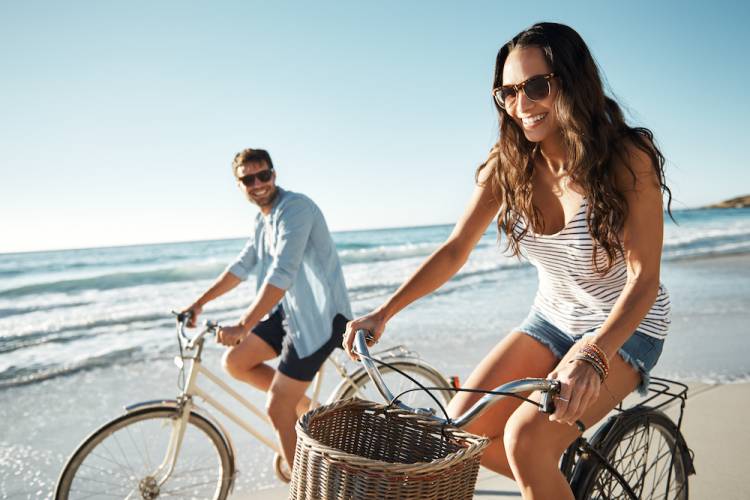 couple riding bikes on beach